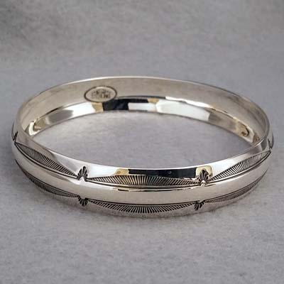 Half-inch wide sterling silver bangle with hand stamped Feather design.  Native American made.